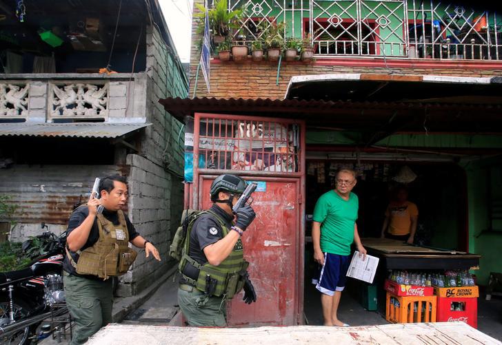 201712asia_philippines_pdea A resident looks at the Philippine Drug Enforcement Agency (PDEA) operatives during their anti-drug operations in Quezon city, metro Manila, Philippines March 16, 2017. 