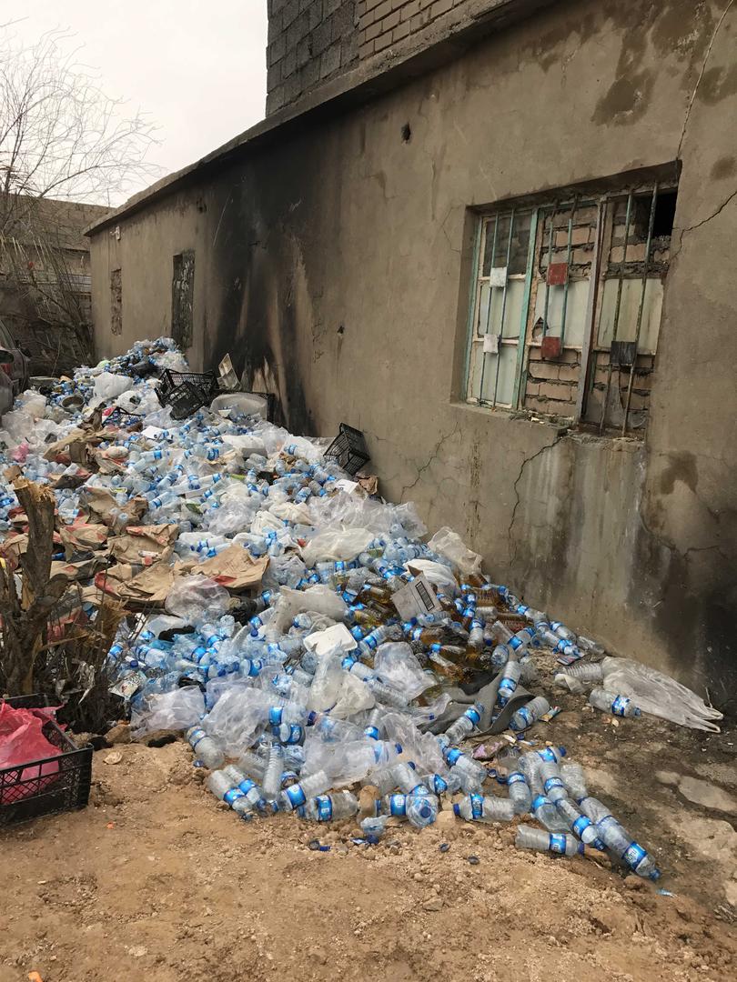 كومة من قوارير المياه مليئة بالبول خارج فتحة في حائط زنزانة مساحتها 3 بـ 4 أمتار تحوي 38سجينا.