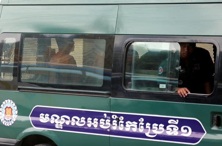 Uon Chhin and Yeang Sothearin, former journalists of the Radio Free Asia (RFA), sit inside a police vehicle as they arrive for a bail hearing at the Appeal Court in Phnom Penh, Cambodia, April 19, 2018. REUTERS/Samrang Pring