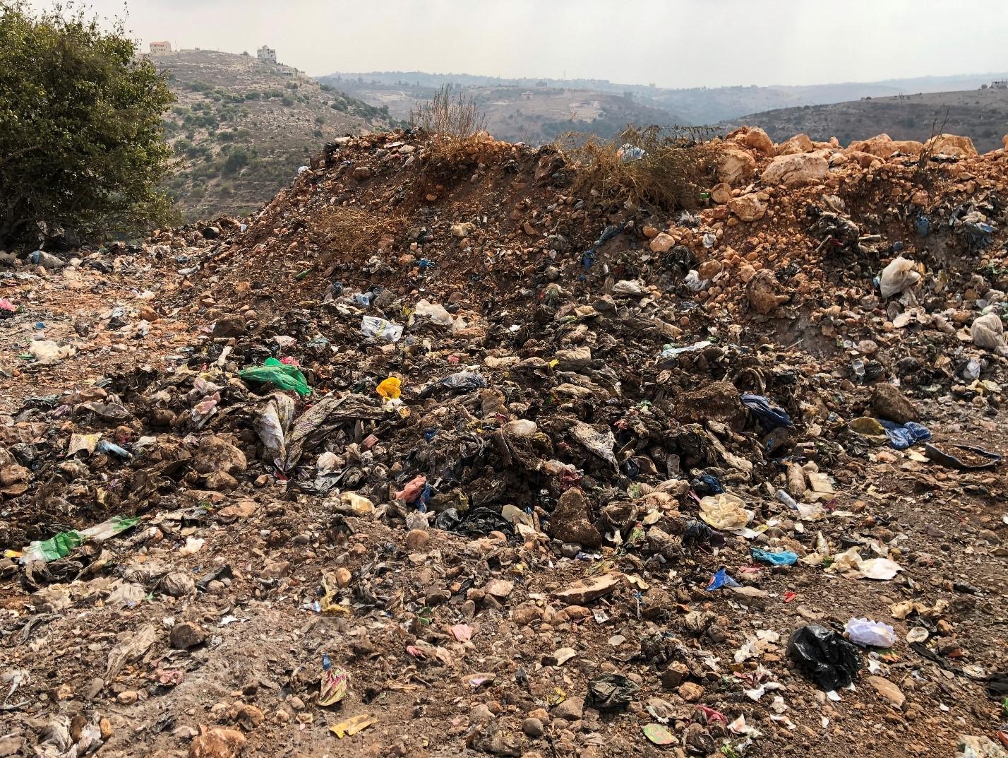 Signs of burning at the al-Qantara dump, including soot from recent burns and ash deposits. 