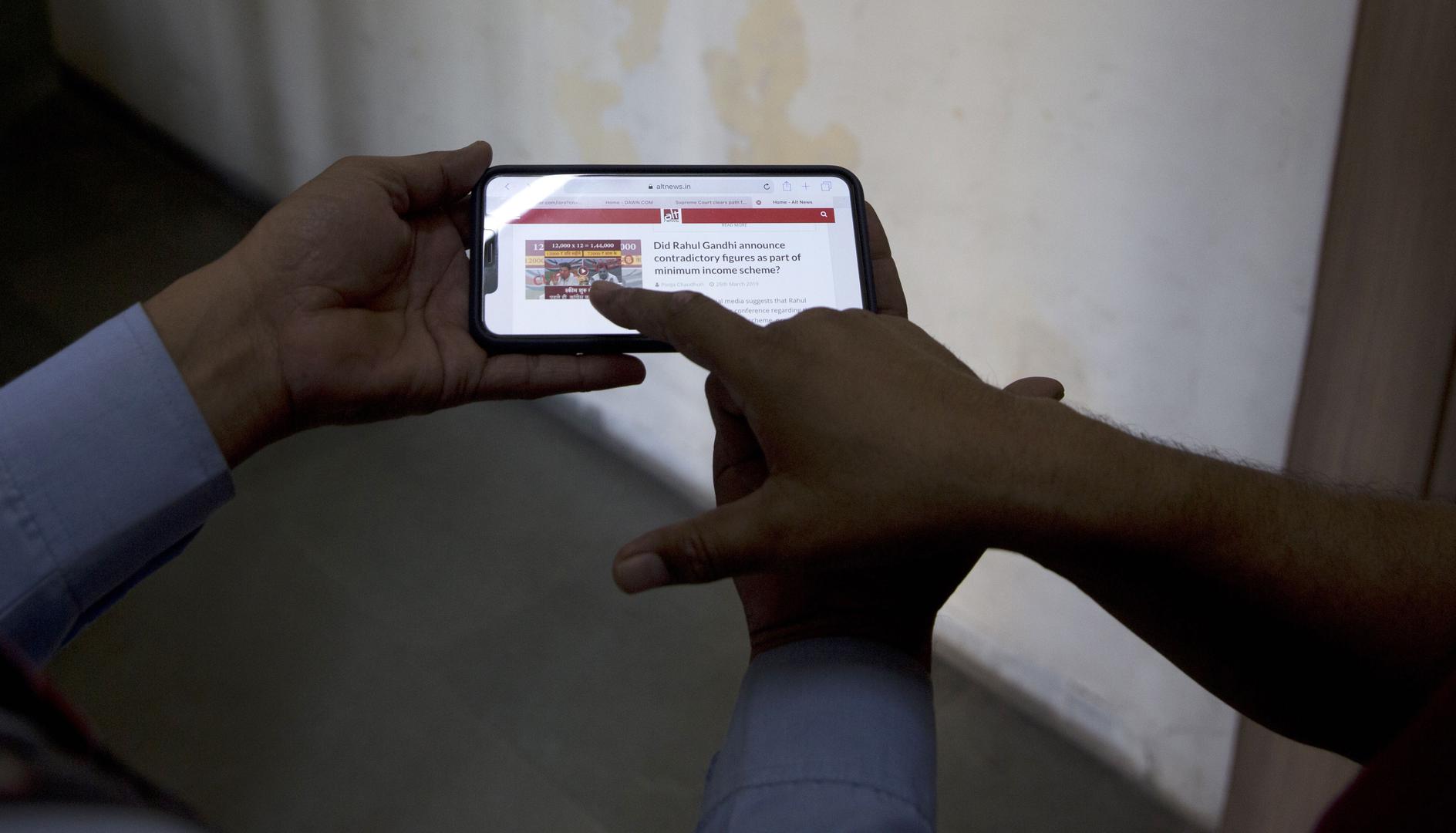 Indians look at a fact-checking website for election related fake news and videos, New Delhi, India, April 3, 2019.