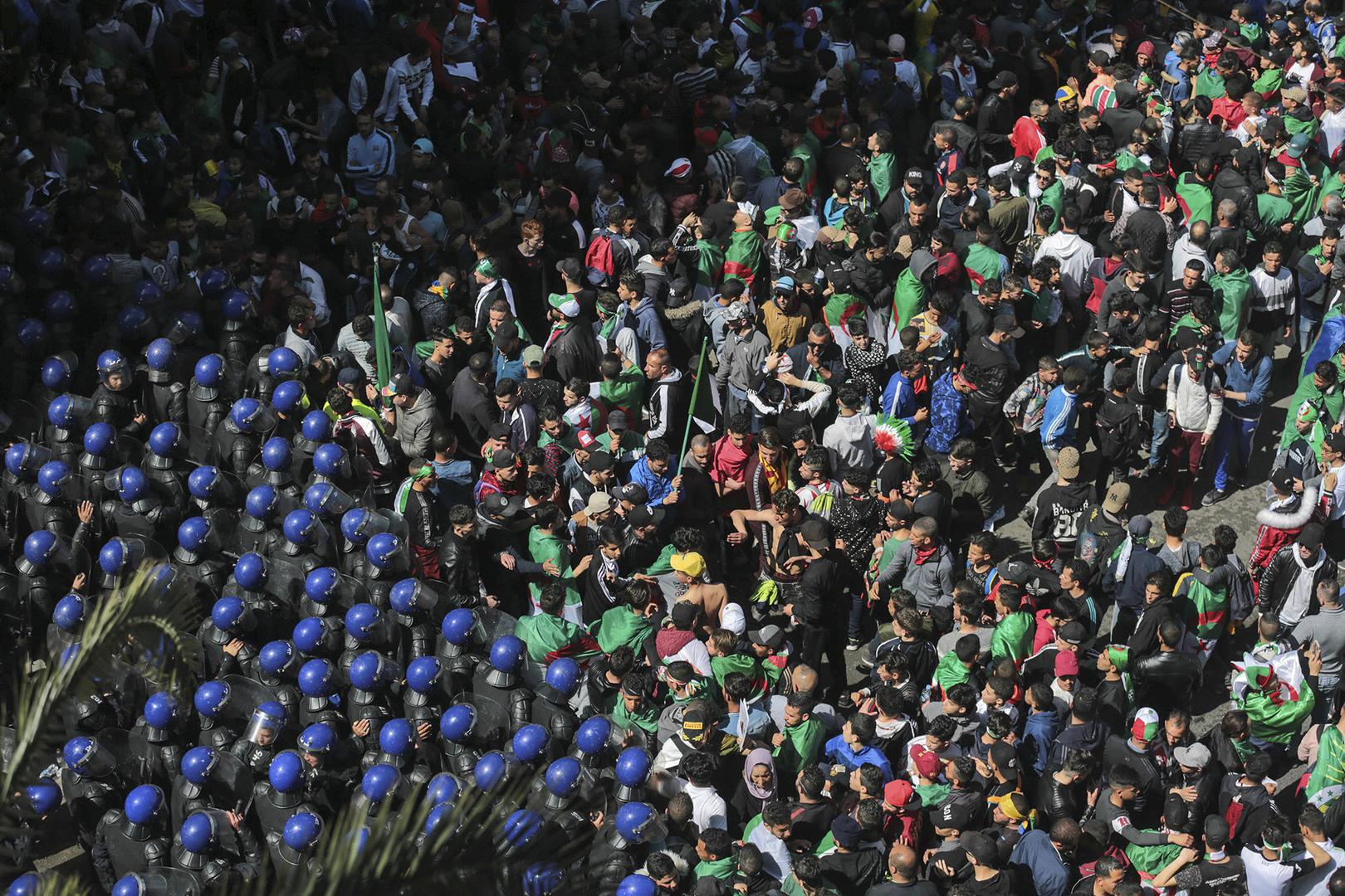 Protesters confront police officers during a demonstration against the country's leadership, in Algiers, Friday, April 12, 2019.