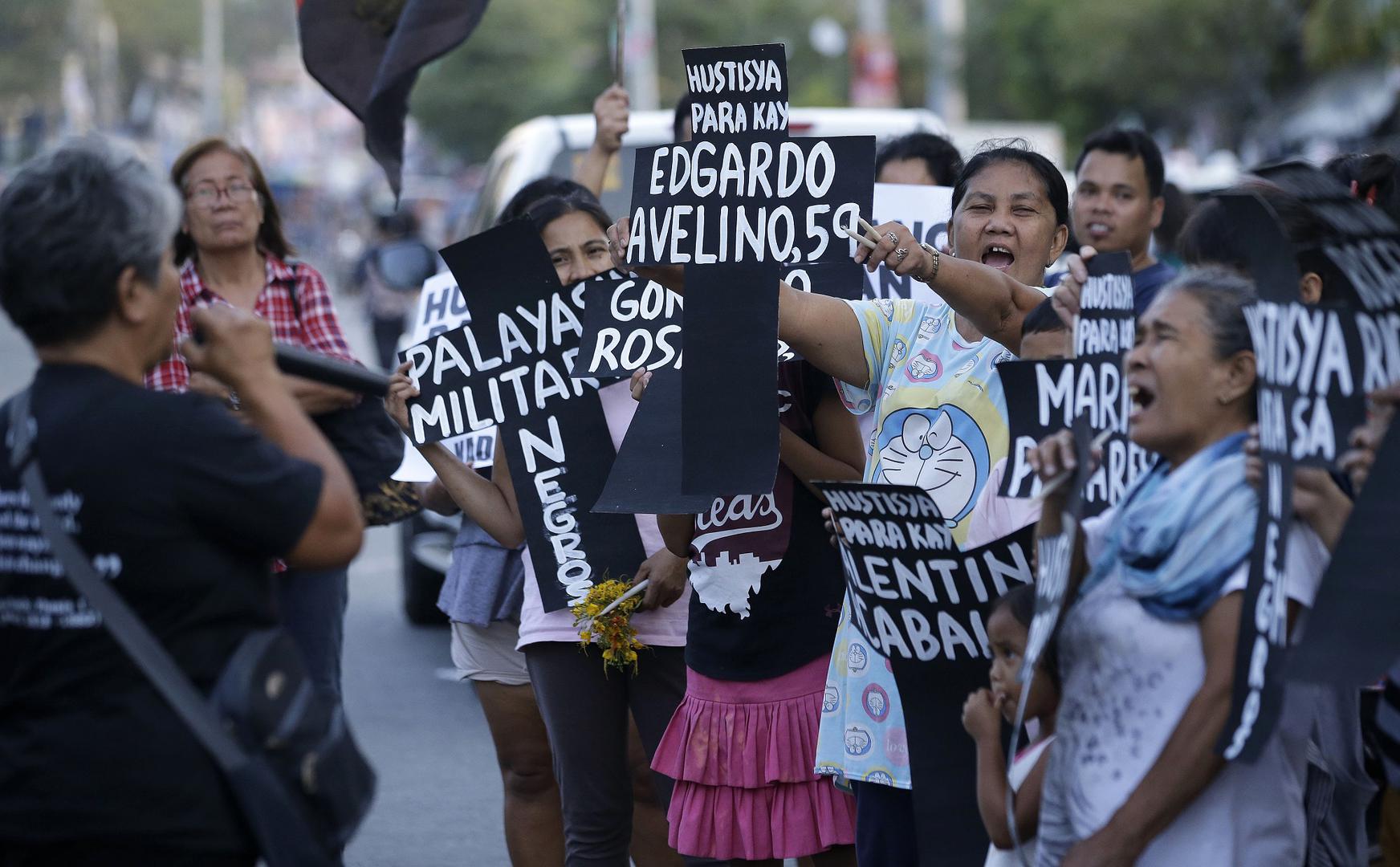 Supporters shout slogans as they hold paper crosses bearing names of killed people from Negros Oriental province during a rally in metropolitan Manila, Philippines on Monday, April 8, 2019.