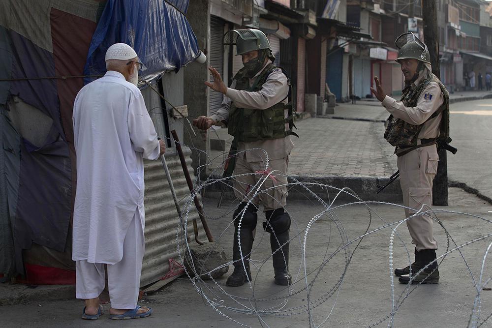 A Kashmiri man is stopped before being allowed to pass near a temporary checkpoint set up by Indian paramilitary soldiers during lockdown in Srinagar,  Friday, August 23, 2019. 