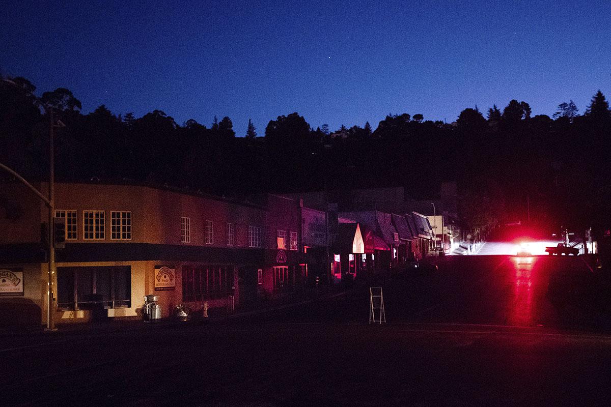 A car drives through a darkened Montclair Village as Pacific Gas & Electric power shutdowns continue in Oakland, California, October 10, 2019.