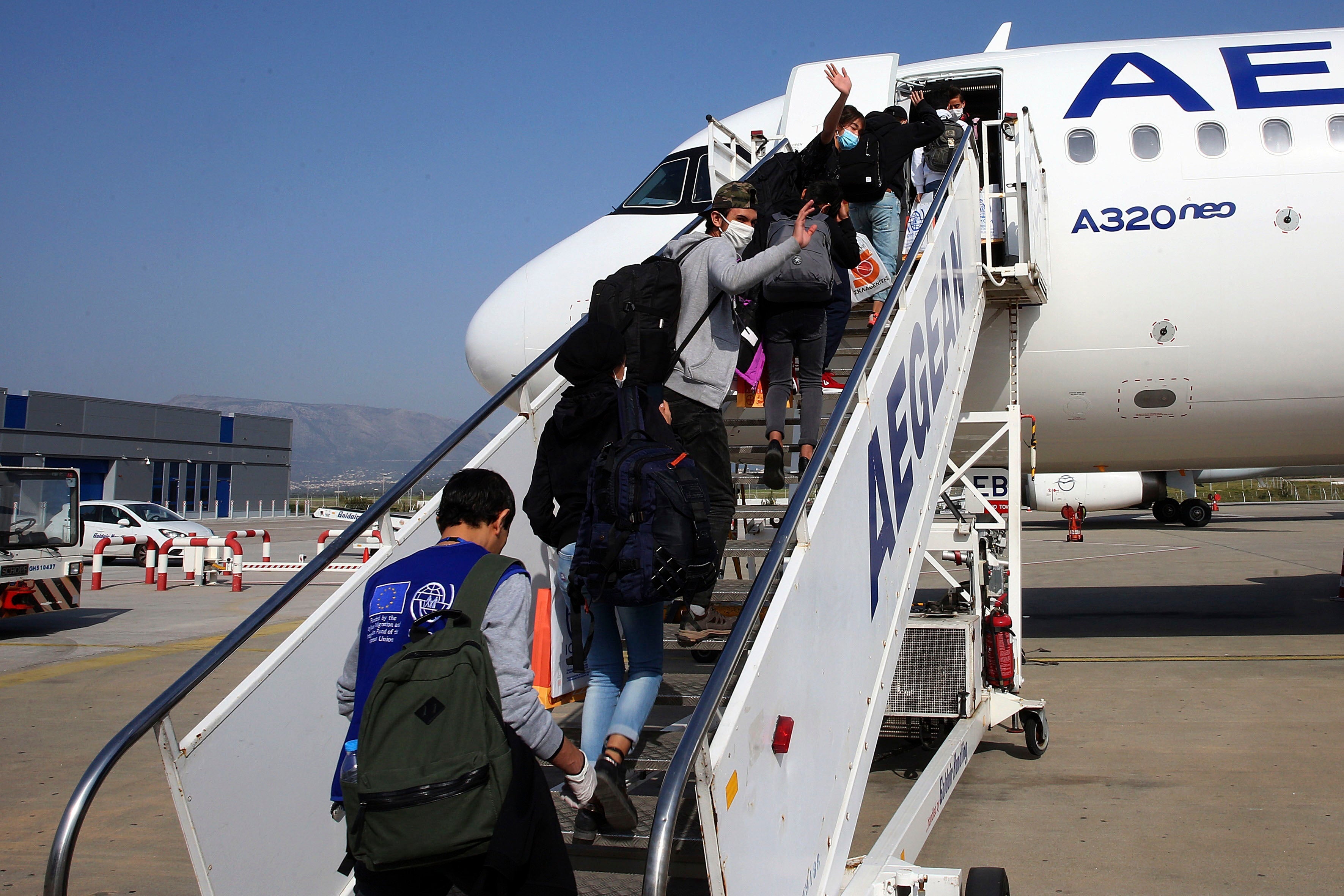 Migrant children board a plane for Luxembourg