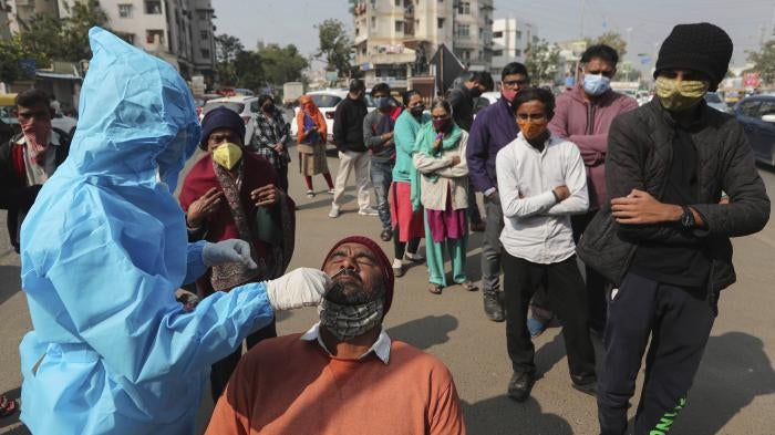 A health worker takes a swab sample of a man to test for Covid-19 in Ahmedabad, India, January 17, 2022.