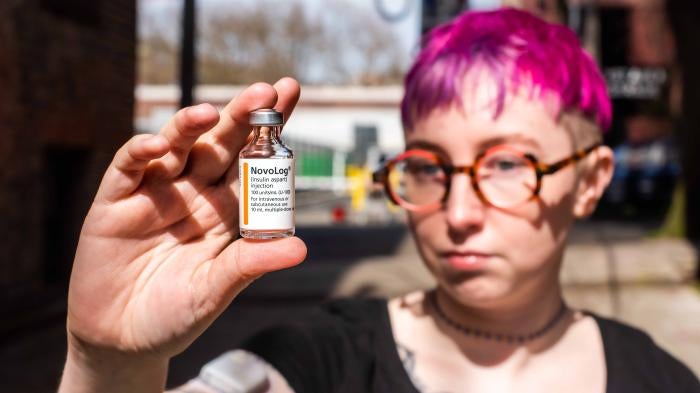 A person holding a vial of insulin