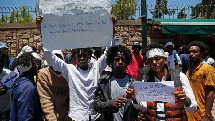 Migrants hold placards during an anti-racism demonstration