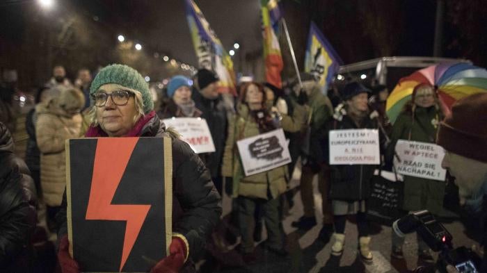 Woman holds a Women's Strike symbol during protest against what they view as an erosion of women’s rights under Poland’s conservative ruling party, Warsaw, Poland, November. 28, 2022 