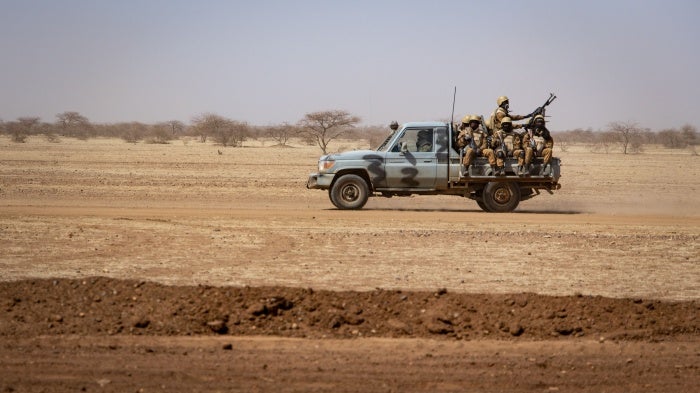 Burkina Faso soldiers patrol aboard a pickup truck on the road from Dori to the Goudebo refugee camp, on February 3, 2020. 