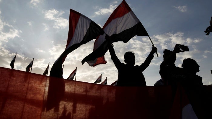 A person waves Yemeni flags during a ceremony marking the anniversary of the September 1962 revolution in Sanaa, Yemen.