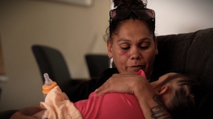 A woman cradles a toddler 