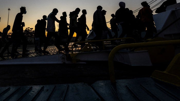 A group of newly-arrived migrants board a ferry in Souda, on the island of Crete, Greece, July 11, 2025.