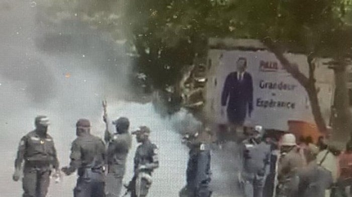 Police surrounded by clouds of tear gas