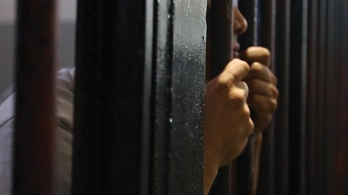 A man behind bars at Sfax detention center; Tunisia, September 26, 2013.