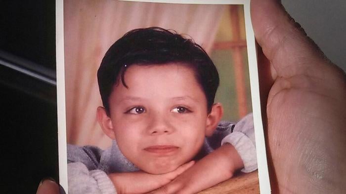 A photograph of Ethan A. (pseudonym) held by his mother, showing her son at age 11, four months before he was arrested for committing a sex offense and placed on the sex offender registry in Texas. 