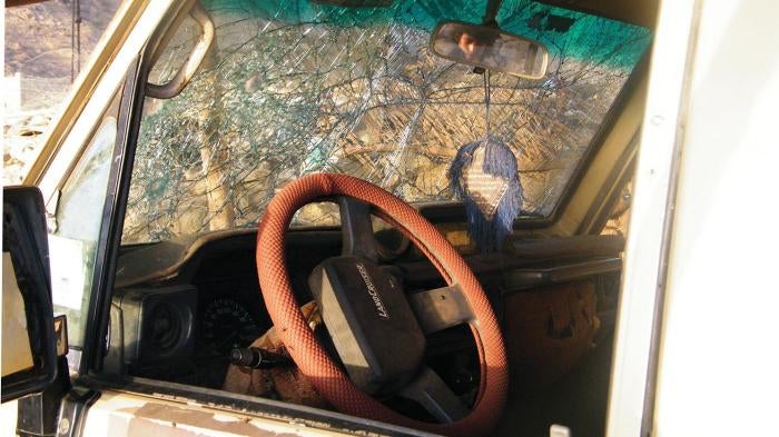 A boy peers into a vehicle damaged in a US drone strike on a wedding procession on December 12, 2013 outside Rad`a, Yemen.