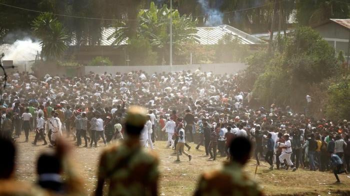 Protestors run from tear gas launched by security personnel during the Irecha, the thanks giving festival of the Oromo people in Bishoftu town of Oromia region, Ethiopia, October 2, 2016.