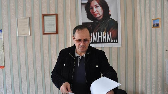 Oyub Titiev stands in front of a portrait of his murdered colleague, Natalia Estemirova, in Memorial's Grozny office, Grozny, Chechnya, Russia. 