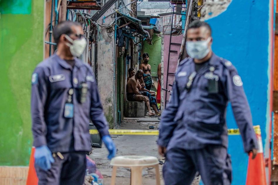 Security personnel patrol a migrant worker accommodation block under quarantine for Covid-19, Malé, Maldives, May 9, 2020.