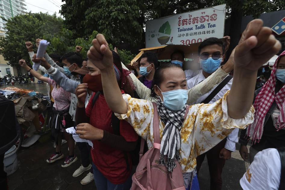 Supporters of Rong Chhun, president of the Cambodian Confederation of Unions, shout slogans in front of Phnom Penh Municipal Court in Phnom Penh, Cambodia, Saturday, Aug. 1, 2020. 