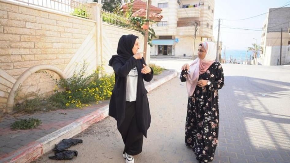 26-year-old Heba AbuJazer (left) and her 25-year-old sister Eman (right), who have hearing disabilities, communicate using sign language in Gaza. 