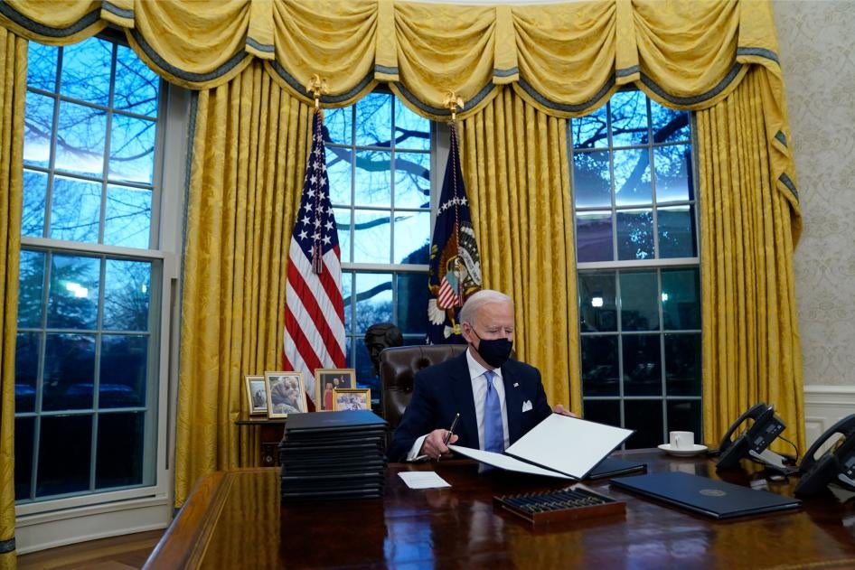 President Joe Biden signs his first executive orders in the Oval Office of the White House in Washington, January 20, 2021. 