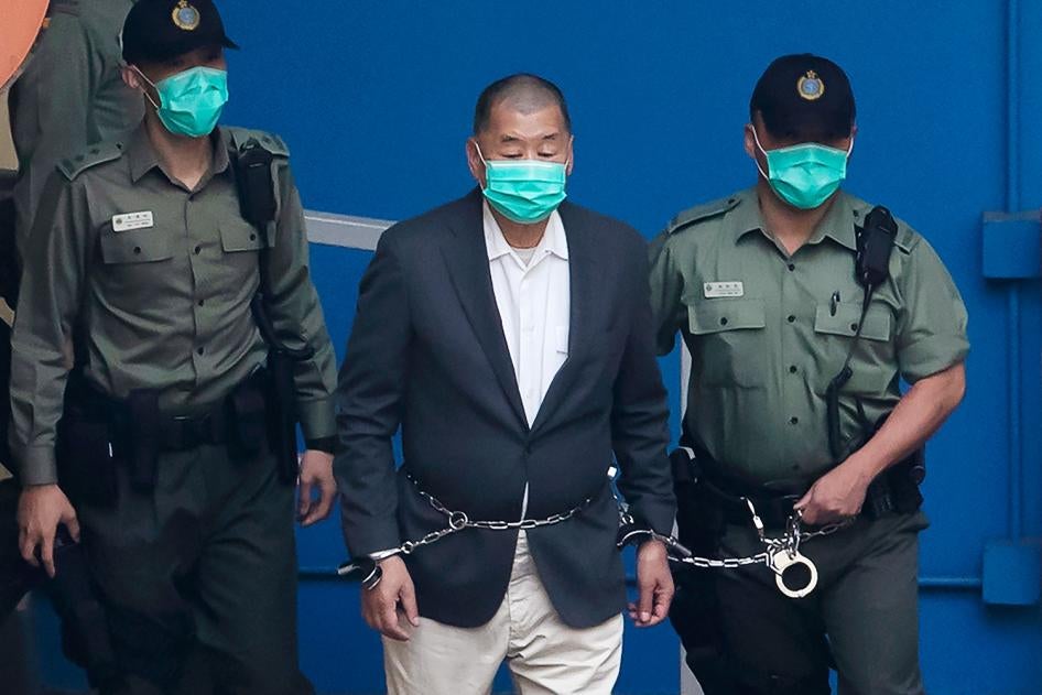 In this December. 12, 2020, file photo, Jimmy Lai,  center, who founded the pro-democracy newspaper Apple Daily, is escorted by Correctional Services officers to get on a prison van before appearing in a court.
