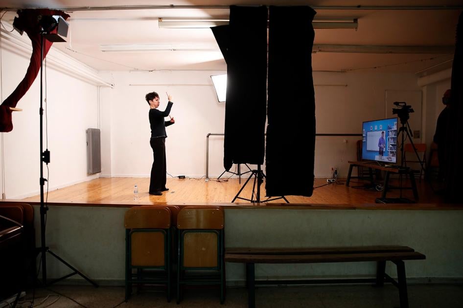 A sign language interpreter records sign language lessons that are broadcast on public television, at an elementary school in Athens, Friday, Nov. 20, 2020. 