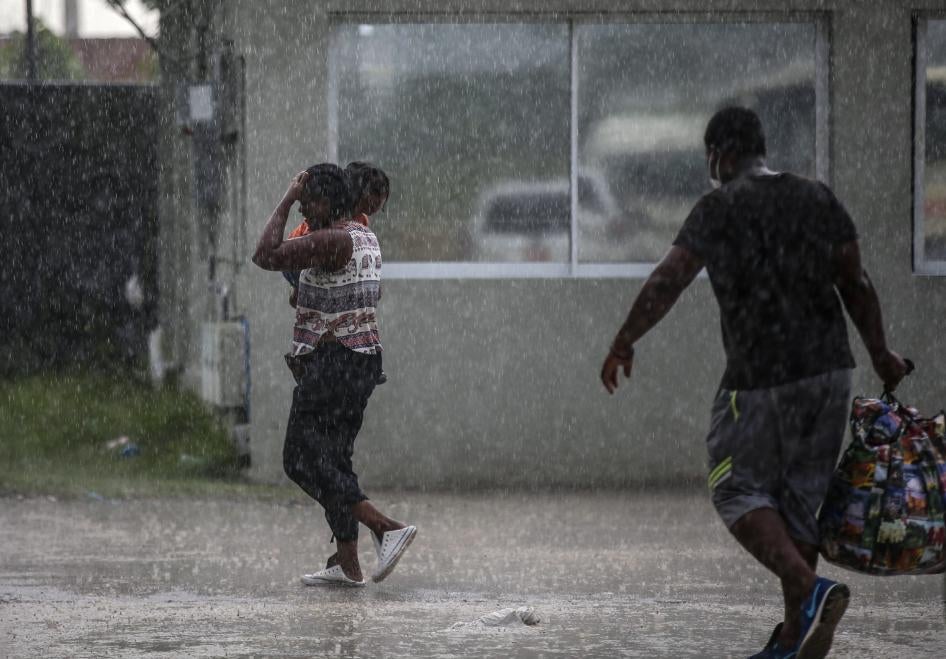 Haitians deported from the United States leave Toussaint Louverture International Airport under a rain shower in Port au Prince, Haiti on September 19, 2021.