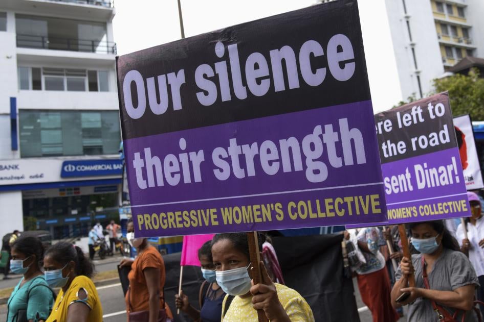 A protester holds a sign that reads "Our Silence, Our Strength"