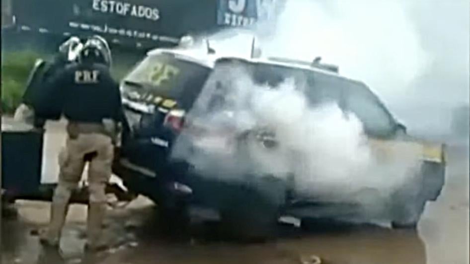 Screengrab from a video shows smoke coming out of a police vehicle