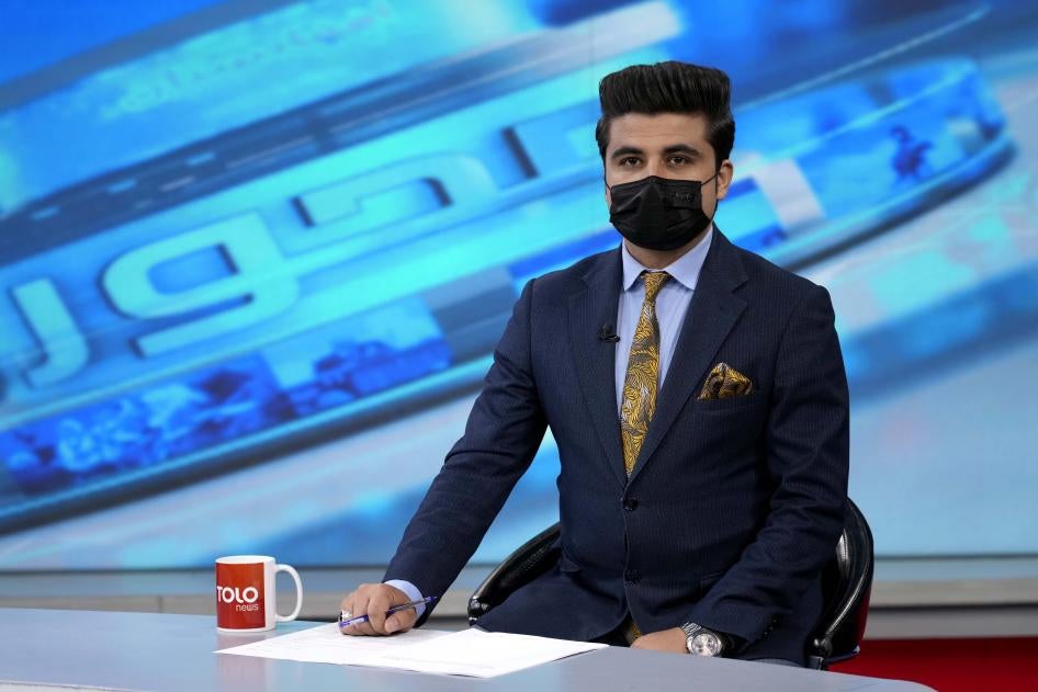 A tv anchor wears a face mask on the air