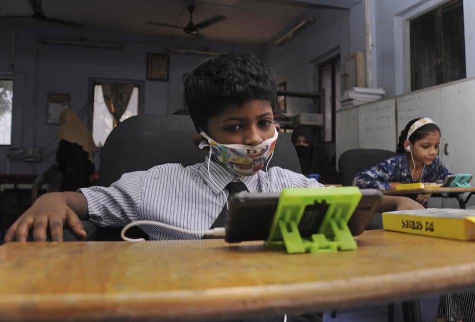 Children studies online using borrowed mobile phones in Mumbai, India.