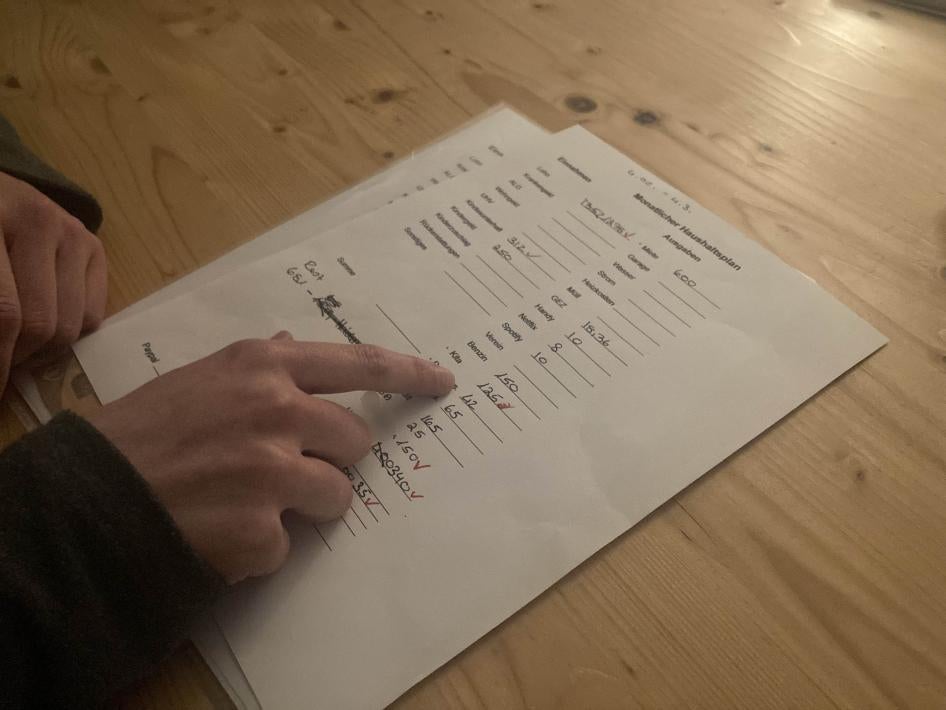 A woman calculates expenses on a sheet of paper