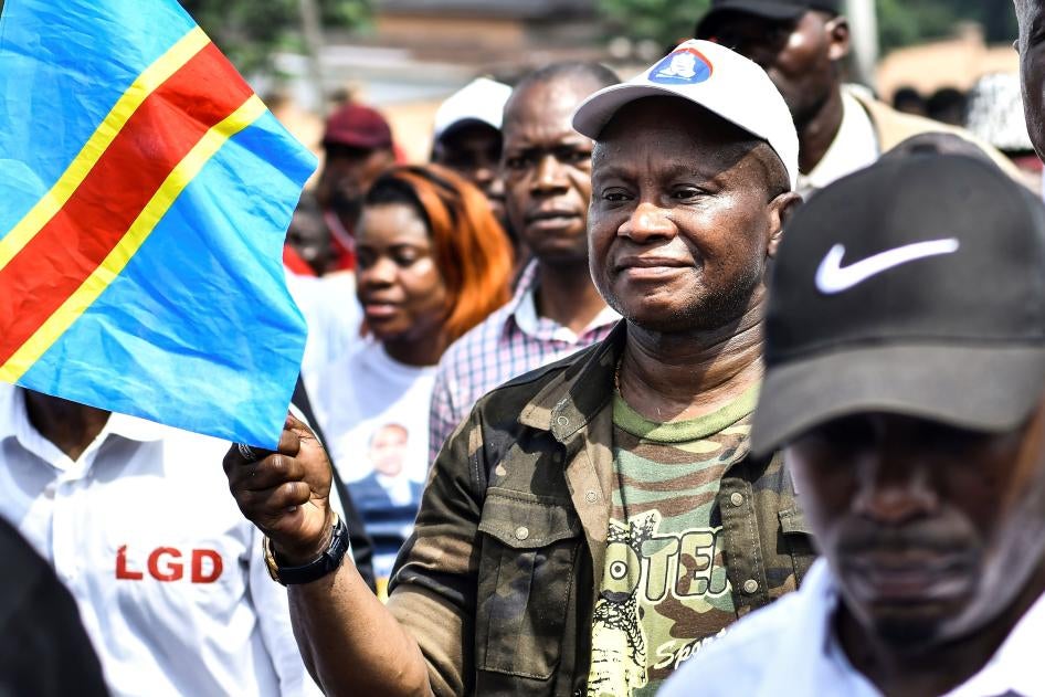 A man holds the flag of Democratic Republic of Congo in a march