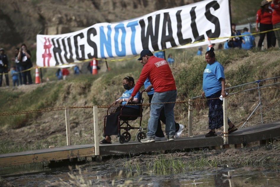 People living in Mexico cross a temporary bridge to meet with relatives living in the U.S., during the 10th annual "Hugs not Walls" event on a stretch of the Rio Grande, in Ciudad Juarez, Mexico, Saturday, May 6, 2023. The brief family reunions are part of a campaign sponsored by the Border Network for Human Rights, an immigration rights group. © 2023 AP Photo/Christian Chavez