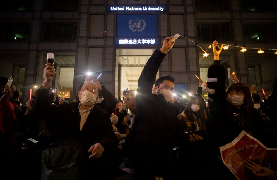 People protest outside a university building at night