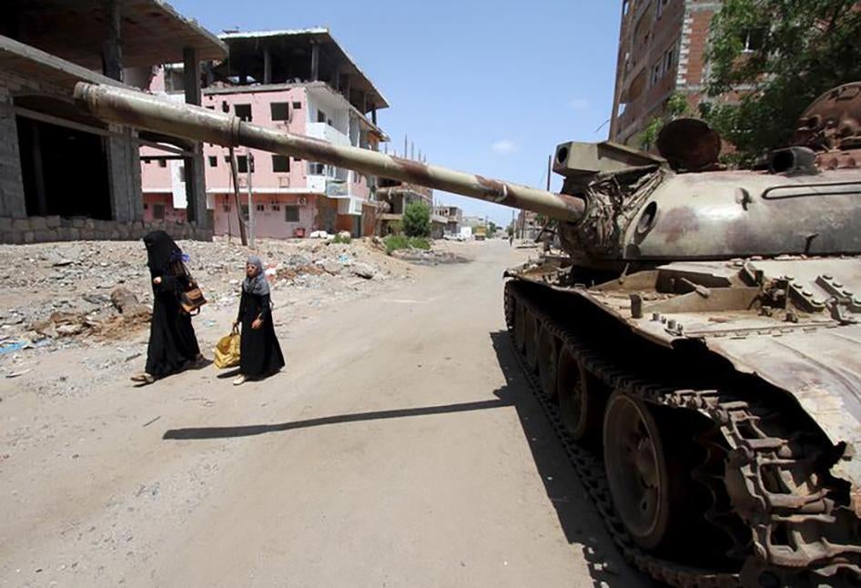 A woman and a girl walk past a broken-down tank on a street in Yemen's southern port city of Aden on September 27, 2015. 