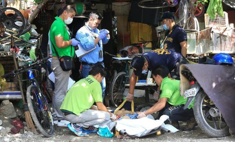 菲律宾国家警察（PNP）扫毒行动击毙五名涉嫌药贩，鉴识人员正在检验其中一具遗体，菲律宾马尼拉都会区奎阿坡市，2016年7月3日。