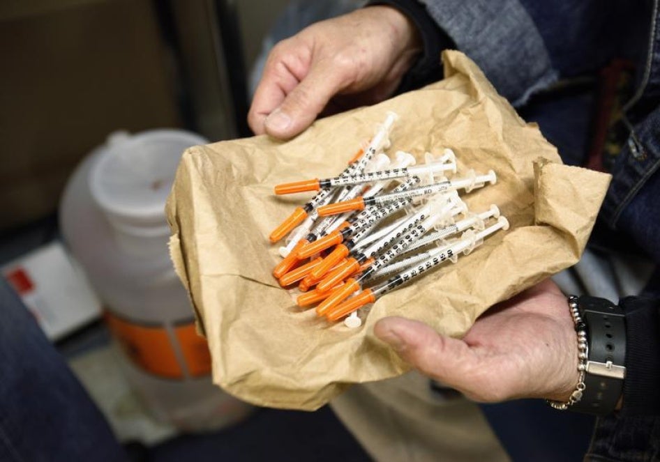 A woman shows her clean syringes at the Aids Center of Queens County needle exchange outreach center in New York, November 28, 2006. 