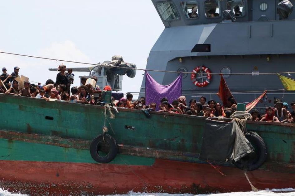A Thai navy vessel tows a boat with migrants away from Thailand, in waters near Koh Lipe island in southern Thailand May 16, 2015.