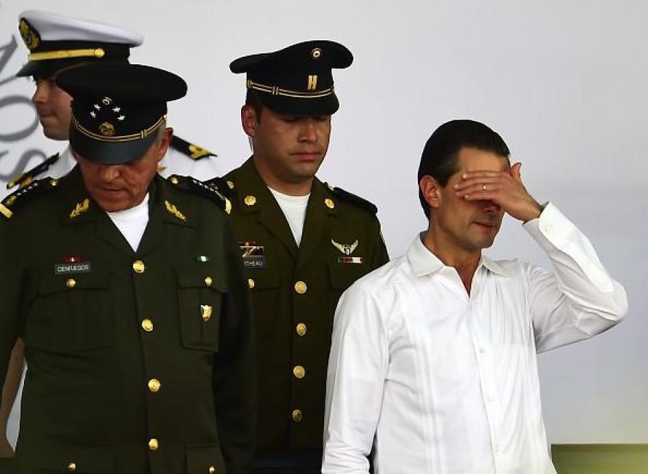 El presidente mexicano Enrique Peña Nieto (derecha) gesticula durante un evento conmemorativo del Día de la Bandera Mexicana en Iguala, estado de Guerreo, México, el 24 de febrero de 2016. 