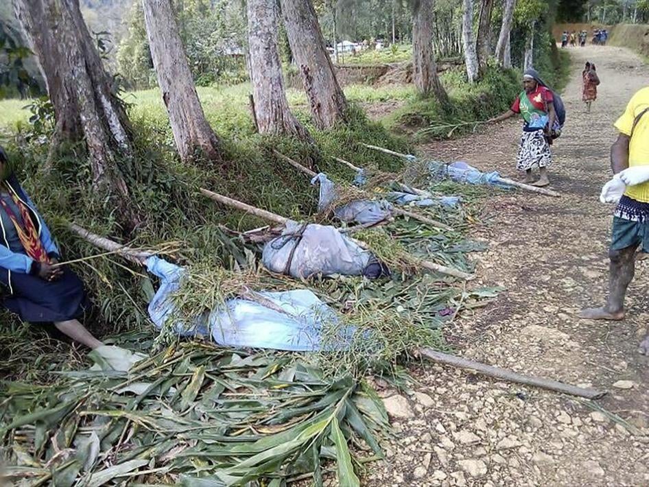 Local residents stand by the bodies of victims recovered in recent tribal violence, Karida, Papua New Guinea, July 8, 2019.