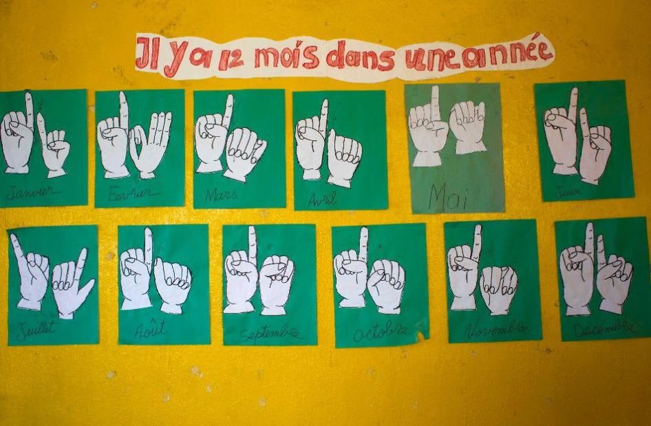 The names of the months in French and sign language are depicted inside a classroom for deaf students in Leveque