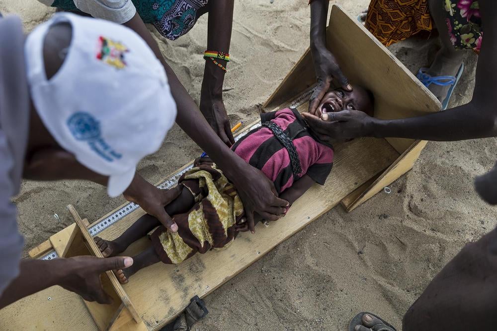 Community health workers measure a child’s height
