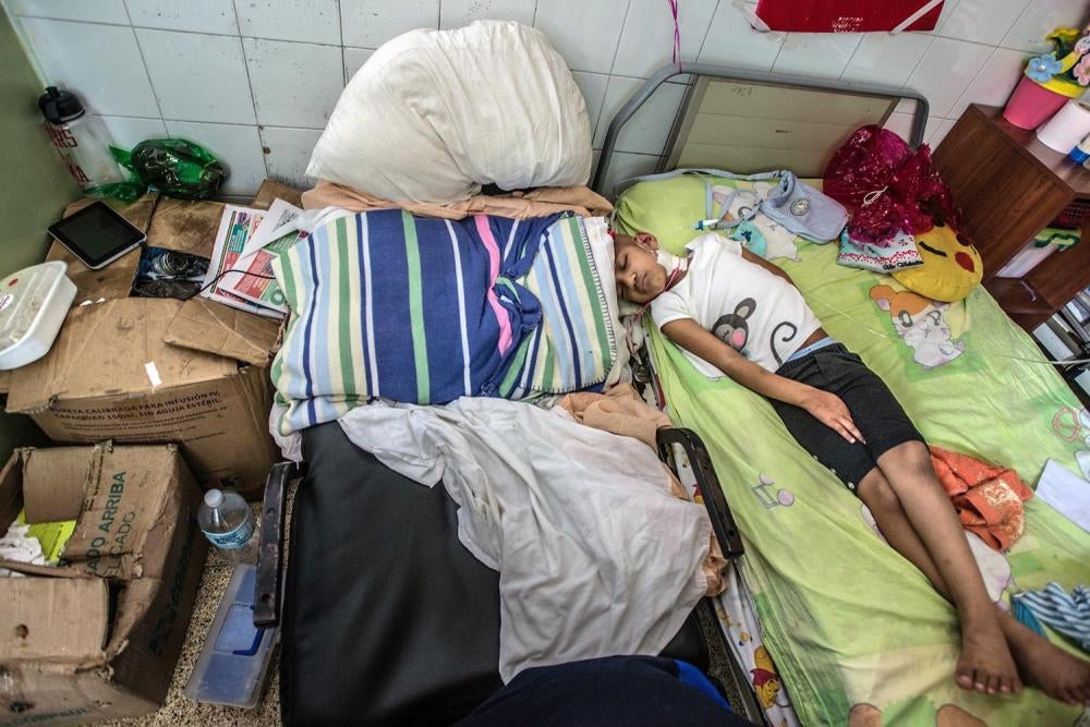 Nicolas Espinoza's young daughter sleeps in the children's cancer ward at the University Hospital Dr. Luis Razetti in Barcelona, April 15, 2016. 