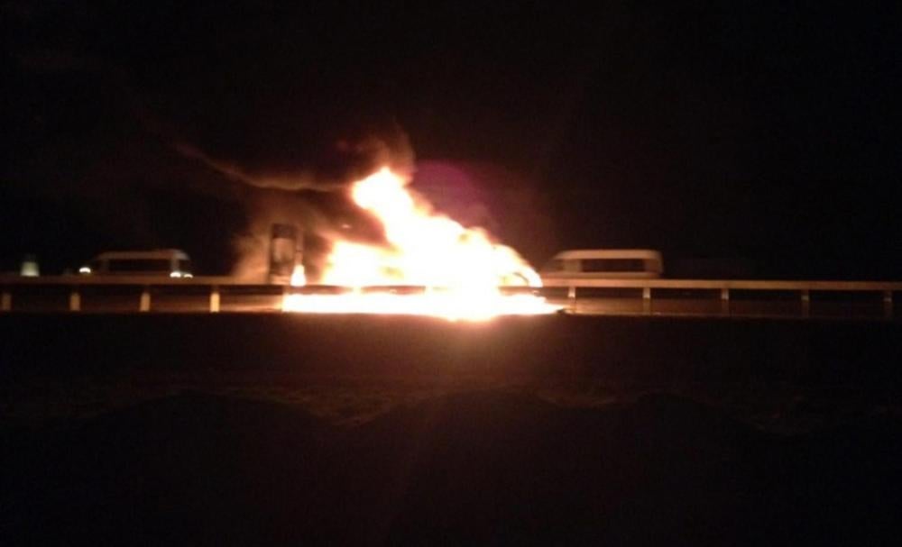 Un bus incendié au bord de l’autoroute près d’Ordzhenikidzevskaya, en Ingouchie, à proximité de la frontière avec la Tchétchénie dans le sud de la Russie, peu après une violente attaque menée le 9 mars 2016 contre des journalistes russes et étrangers qui 