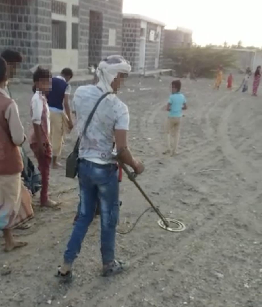 A deminer works with children following him in a town on the western coast. © 2018 Private